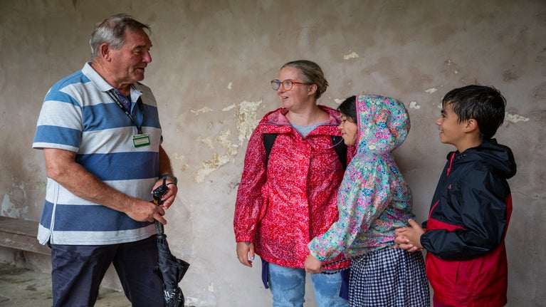 A volunteer talking to a family at Godolphin, Cornwall.